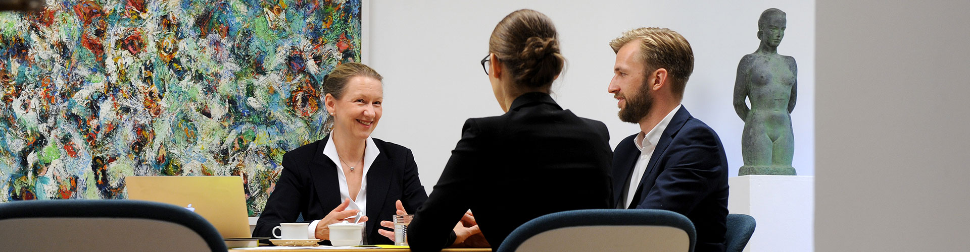 Dagmar Saschek an einem Konferenztisch mit zwei Gesprächspartnern.
