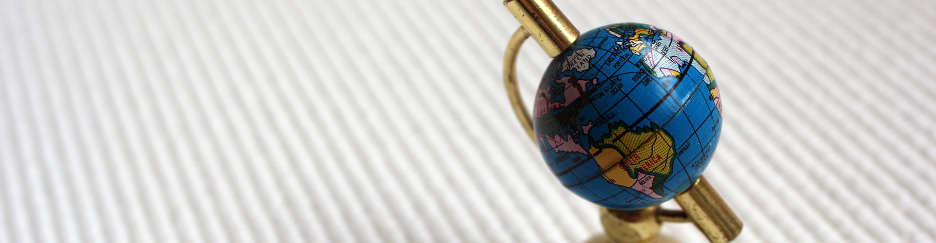 A miniature globe on a white ribbed background.